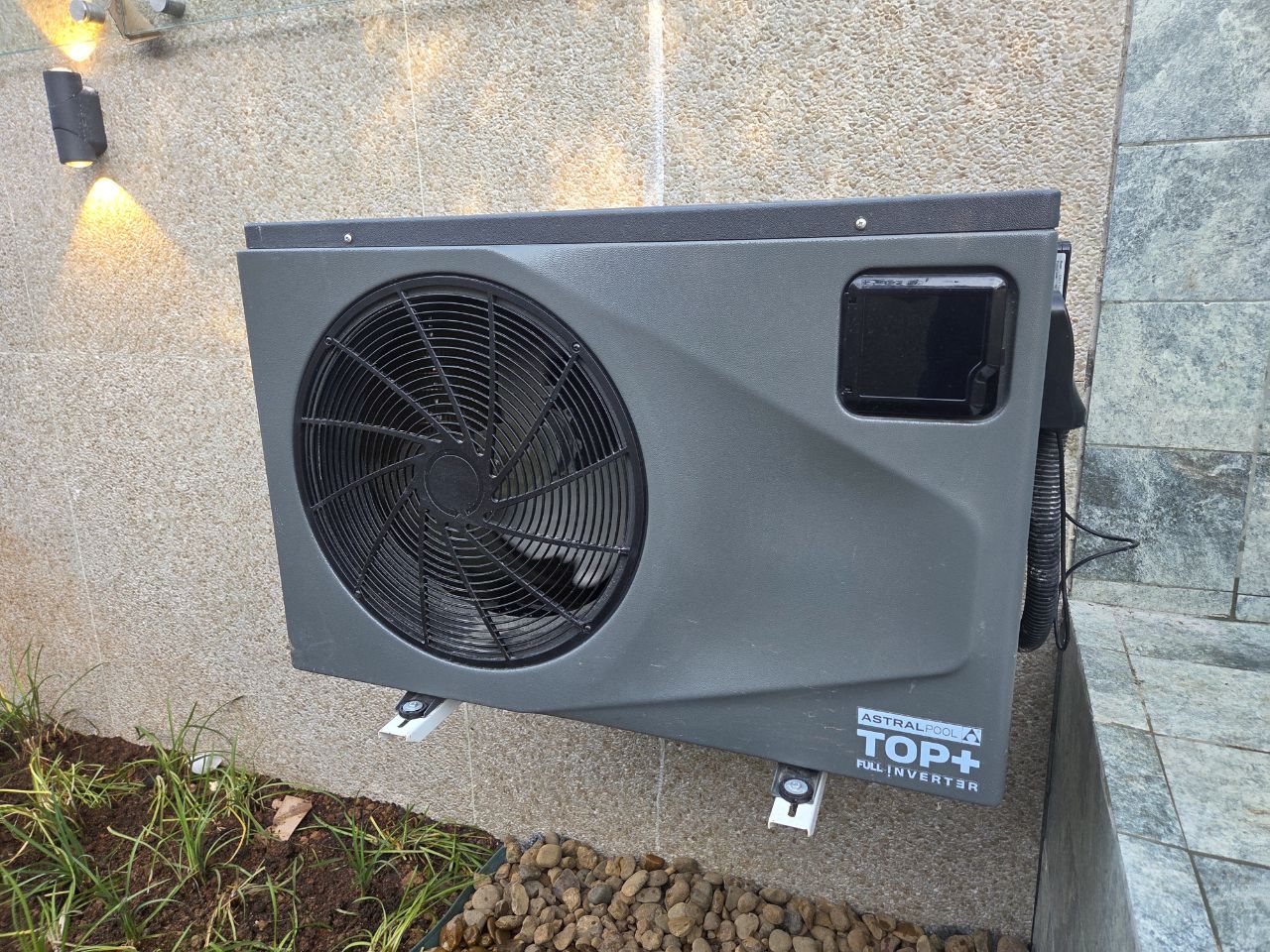 Bomba de calor AstralPool Top+ Full Inverter instalada pela Pointpool em parede de pedra